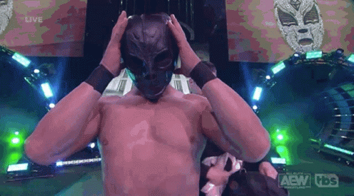A Man Without A Shirt Is Wearing A Mask And A Tbs Logo Is Behind Him GIF