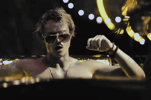 A Man Without A Shirt Is Wearing Sunglasses And A Watch GIF