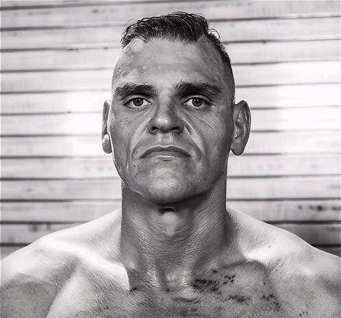 A Man Without A Shirt Looks At The Camera With A Serious Look On His Face GIF
