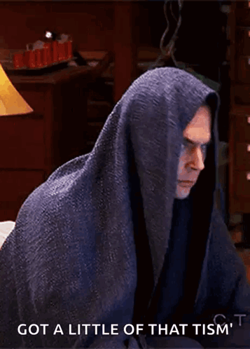 A Man Wrapped In A Blanket With The Words Got A Little Of That Tism 'T Written Below Him GIF