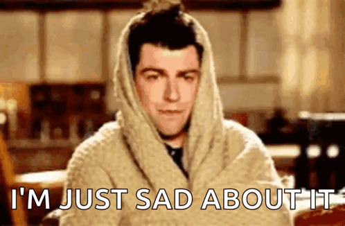 A Man Wrapped In A Blanket With The Words `` I 'M Just Sad About It '' On His Face . GIF