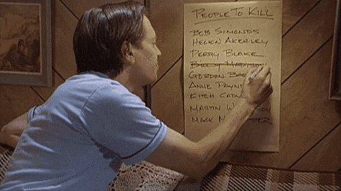 A Man Writes On A Piece Of Paper With People To Kill Written On It GIF