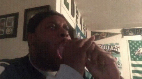 A Man Yawning In Front Of Eagles Posters GIF