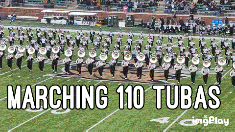 a marching 110 tubas band is marching on a field
