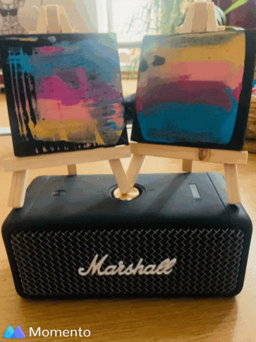A Marshall Speaker Sits On A Table Next To Two Small Easels GIF