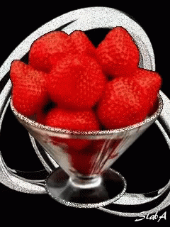 A Martini Glass Filled With Red Strawberries With A Black Background GIF