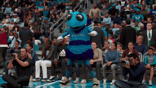 A Mascot For The Charlotte Hornets Stands In Front Of A Crowd Of People GIF