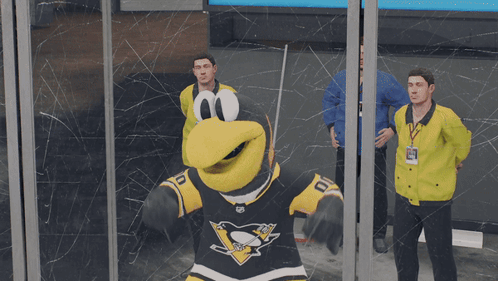 A Mascot For The Penguins Is Standing In Front Of A Glass Wall GIF