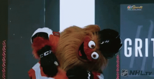 A Mascot For The Philadelphia Flyers Is Dancing In Front Of A Nhl Tv Sign GIF