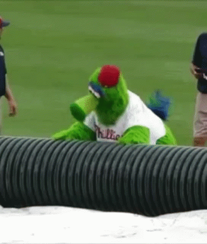 A Mascot For The Phillies Is Sitting On A Black Pipe GIF