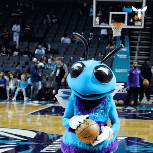 A Mascot Holding A Basketball On A Basketball Court GIF