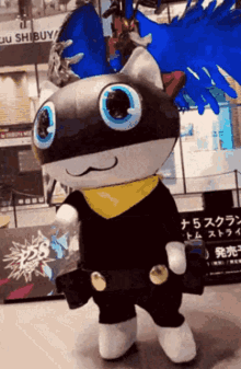 A Mascot Is Standing In Front Of A Building That Says Shibuya GIF