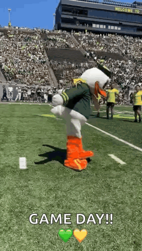 a mascot is standing on a football field with a crowd in the background .
