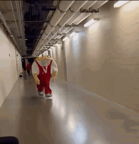 a mascot is walking down a hallway with pipes