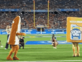 A Mascot Is Walking On A Football Field While Holding A Box That Says Popeye 'S GIF