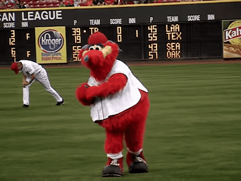 A Mascot On A Baseball Field In Front Of A Scoreboard That Says San League On It GIF