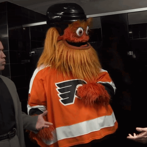 A Mascot Wearing A Flyers Jersey Talks To A Man GIF