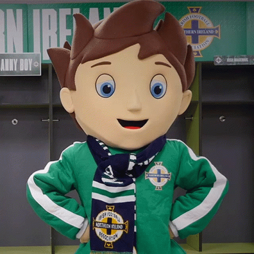 A Mascot Wearing A Green Jacket And A Blue Scarf With Northern Ireland On It GIF