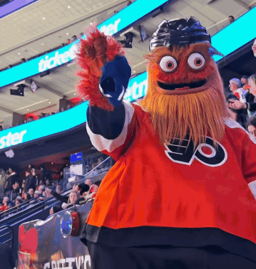 A Mascot Wearing A Jersey That Says Flyers Stands In Front Of A Crowd GIF