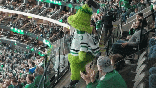 A Mascot Wearing A Number 10 Jersey Stands In A Crowded Stadium GIF