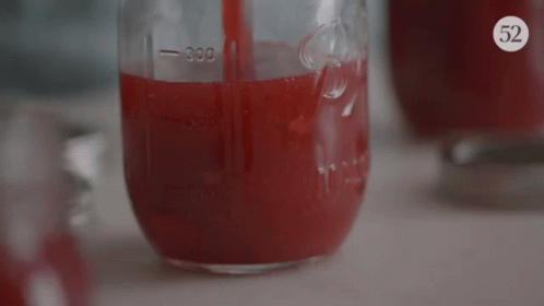 A Mason Jar Filled With Red Liquid Has The Number 300 On The Side GIF