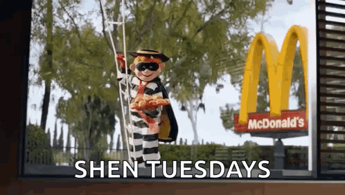 A Mcdonald 'S Advertisement With A Doll Dressed As A Prisoner Holding A Pizza GIF