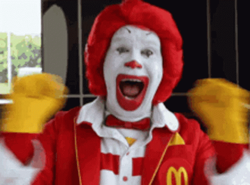 A Mcdonald 'S Clown With A Red Wig And White Face GIF