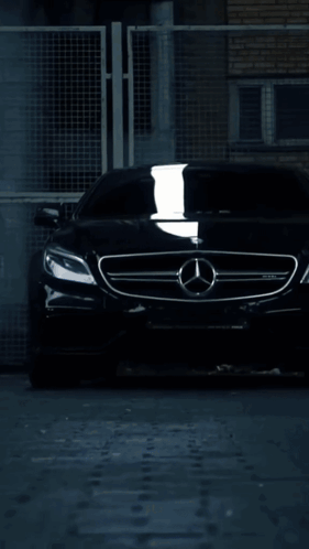 A Mercedes Car Is Driving Down A Wet Road At Night GIF