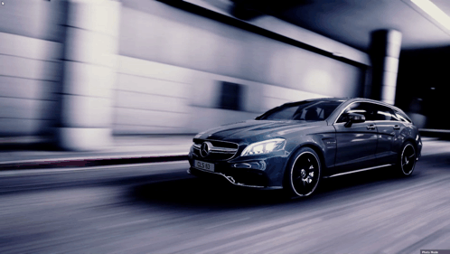 A Mercedes Cls 63 Amg Is Driving Down A Street GIF