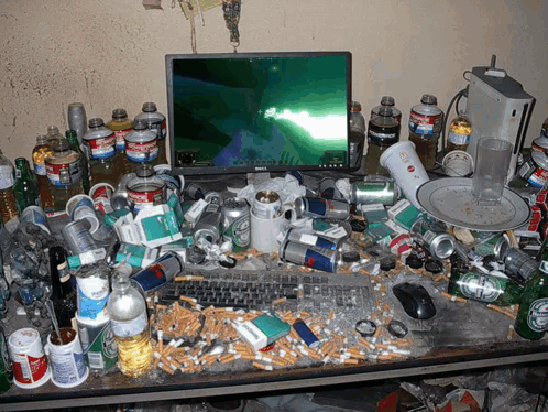 A Messy Desk With A Dell Monitor And Coca Cola Bottles GIF