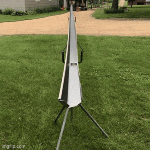 A Metal Pipe Is Sitting In The Middle Of A Grassy Field GIF