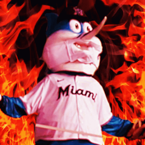 A Miami Mascot Is Standing In Front Of A Fire GIF