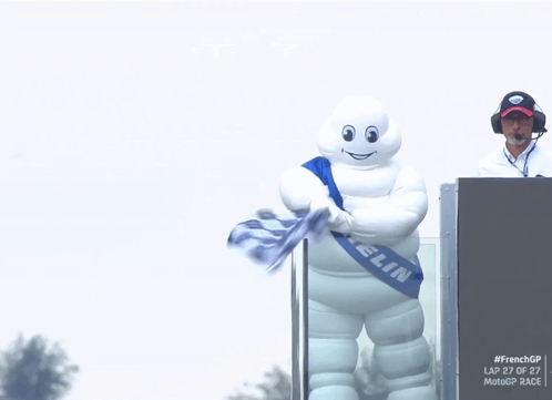 A Michelin Mascot Is Holding A Flag GIF