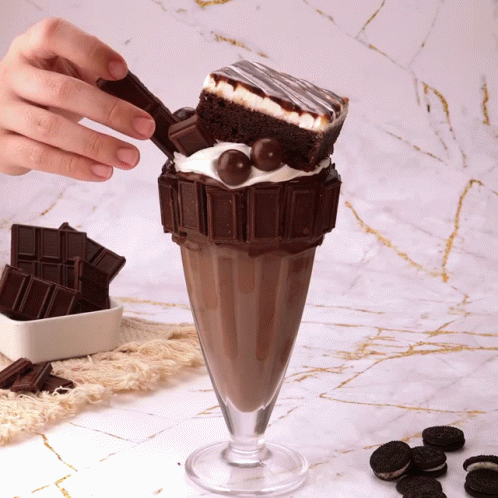A Milkshake With A Brownie And Oreos On It GIF