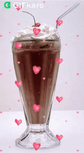 A Milkshake With Whipped Cream And A Cherry On Top Is Surrounded By Pink Hearts GIF