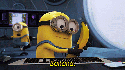 Minion Holding Banana In Front Of Keyboard GIF