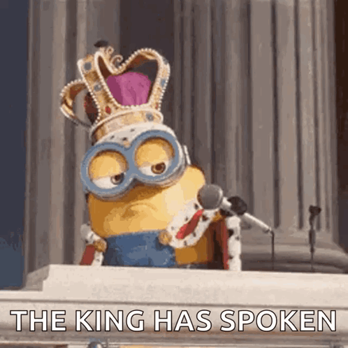 A Minion Wearing A Crown And Goggles Is Speaking Into A Microphone And Says " The King Has Spoken " GIF