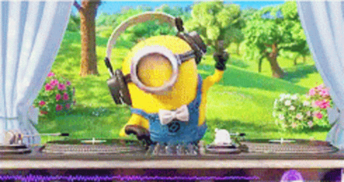 A Minion Wearing Headphones And Goggles Is Standing In Front Of A Table . GIF