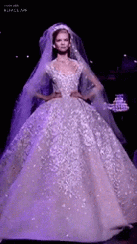 A Model Is Walking Down The Runway Wearing A Purple Wedding Dress . GIF