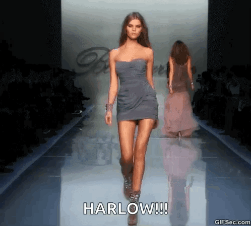 A Model Walks Down A Runway At A Fashion Show With The Caption Harlow !!! GIF