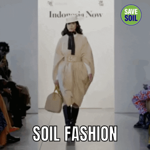 A Model Walks Down A Runway At A Fashion Show With The Words Soil Fashion Behind Her GIF