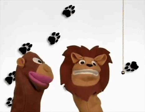 A Monkey And A Lion Puppet Are Standing Next To Each Other With Paw Prints Behind Them GIF