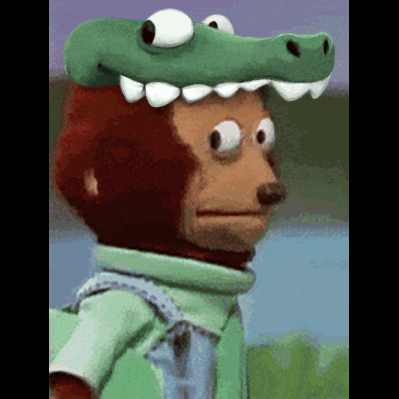 A Monkey Wearing A Green Crocodile Hat Looks At The Camera GIF