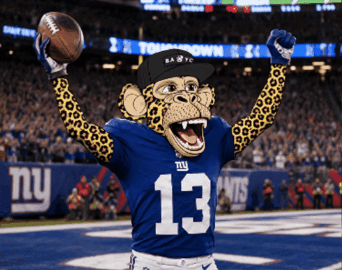A Monkey Wearing A Ny Giants Jersey Holds A Football In His Hands GIF