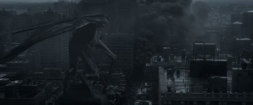 A Monster Is Standing In The Middle Of A City With Smoke Coming Out Of It 'S Mouth GIF