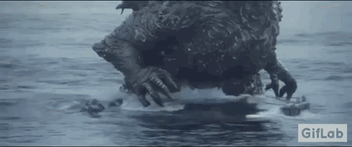 A Monster Is Swimming In The Ocean With A Remote Control In Its Mouth . GIF