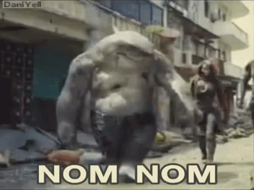 A Monster Is Walking Down A Street With The Words Nom Nom Written On The Bottom GIF