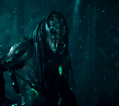 A Monster With Dreadlocks And Sharp Teeth Stands In The Dark GIF