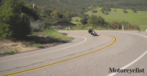 A Motorcycle Is Going Down A Curvy Road With The Words Motorcyclist Below It GIF
