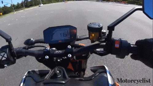 A Motorcyclist Is Riding A Ktm Motorcycle Down The Road GIF